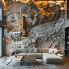 a living room with large rocks on the wall and couches in front of it