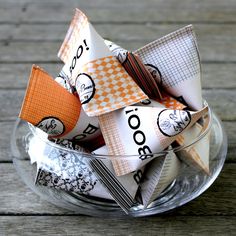 an origami pinwheel in a glass bowl on top of a wooden table