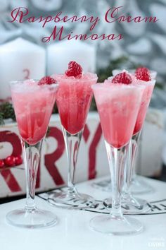 three glasses filled with raspberry garnish on top of a table