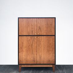 a wooden cabinet with two doors and black handles