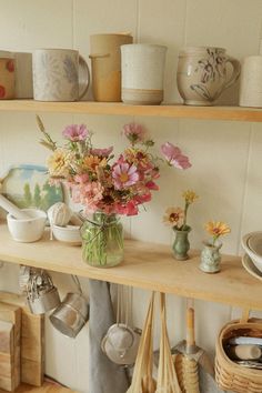 a shelf filled with lots of vases and flowers on top of it's shelves