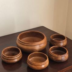 four wooden bowls sitting on top of a table