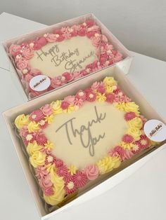 two decorated birthday cakes in a box with thank you written on the top and bottom