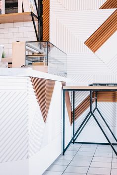 the interior of a restaurant with white walls and wood accents