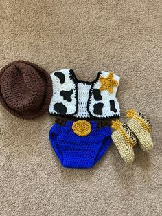 a crocheted hat, mittens and booties are laying on the floor