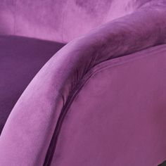 a close up of a purple couch with the arm and foot rest down on it