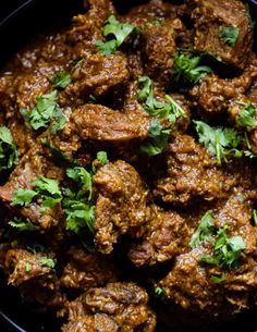 meat with cilantro and parsley in a black bowl