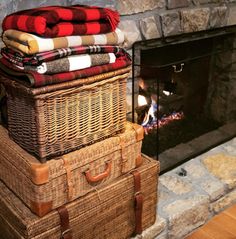 two wicker trunks stacked on top of each other in front of a fireplace