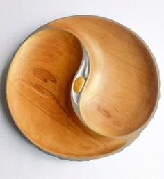 a wooden bowl sitting on top of a white table