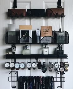 a wall mounted shelf filled with lots of watches and other items next to a door