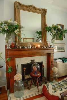 a living room filled with furniture and a fire place covered in flowers next to a mirror