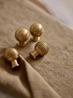 three gold knobs on a beige cloth