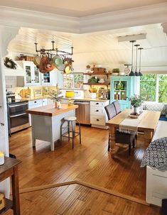 a kitchen filled with lots of furniture and wooden floors