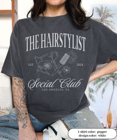 the hairstylist t - shirt is worn by a woman with tattoos on her arm