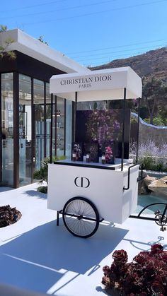 an ice cream cart with wheels on the side and flowers growing out of it's sides