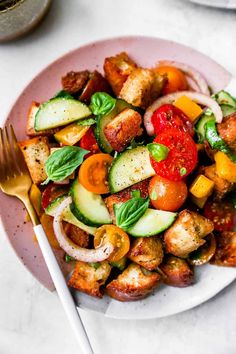 a white plate topped with meat and veggies on top of a table next to a fork