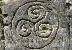 a stone carving with two spirals on it's face in the rock wall