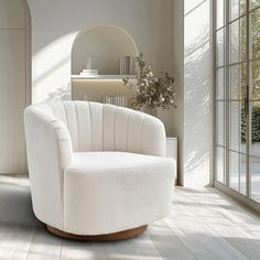 a white chair sitting on top of a hard wood floor next to a wall with windows