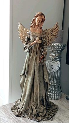 an angel figurine is standing next to a vase