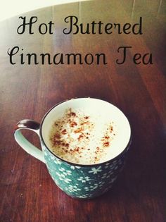 hot buttered cinnamon tea in a mug on a wooden table with the words hot buttered cinnamon tea