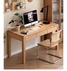 a wooden desk with a computer on top of it next to a wall mounted clock