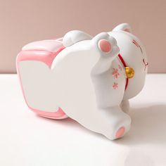 a white and pink toy elephant on a table