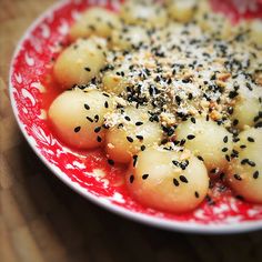 a red and white plate topped with potatoes covered in seasoning