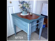 a blue table with flowers on top and the bottom half painted in teal green