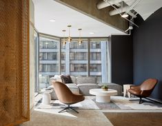 a living room filled with furniture and tall windows