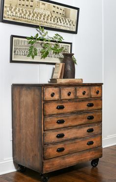 an old dresser with some books and a potted plant on top