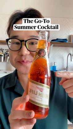 a man holding up a bottle of beer in front of him with the caption that reads, the go - to summer cocktail