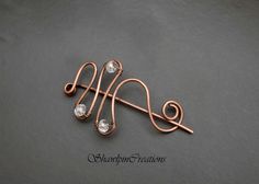 a copper wire and crystal bead brooch pin