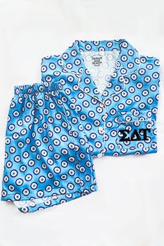 Our Greek Letter Evil Eye Pajamas are made from an ultra soft satin blend fabric, feature a breathable and airy fit, and are comfortable beyond your nightly dreams. With each piece uniquely designed by us, our small team puts an abundance of time, love, dedication, and detail into our eclectic loungewear collection. We are proud to female and family owned & officially Greek licensed. Features a button front shirt, single chest pocket, and elastic waist shorts with pockets. Your sorority letters Preppy Pjs, Sleep Ware, Kappa Delta Chi, Phi Sigma Rho, 2024 Clothes, Alpha Epsilon Phi, Preppy Life, Delta Chi, Sigma Delta Tau