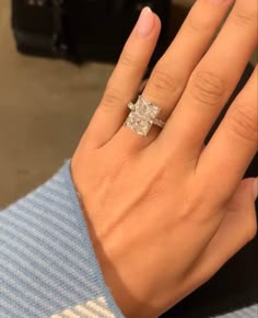 a woman's hand with a diamond ring on it