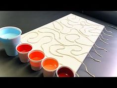 three cups are sitting on a table with paint