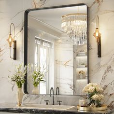 a bathroom with marble counter tops and a large mirror on the wall over the sink