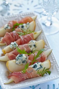 appetizers with prosciutto, pears and blue cheese on a white platter