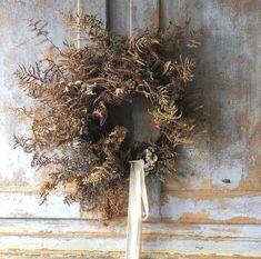 a dried wreath hanging on the side of a door