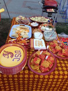 a picnic table filled with food and snacks on it's sides, including crackers