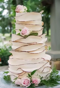 a white wedding cake with pink roses on top