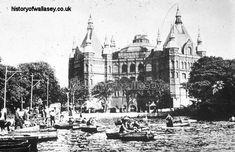 an old black and white photo of people on boats in front of a large building