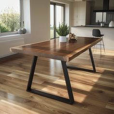 a wooden table sitting on top of a hard wood floor next to a large window