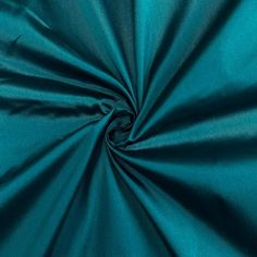 a close up shot of the teal green color of an unlined satin fabric