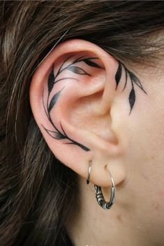 a woman's ear with an artistic design on the middle part of her ear