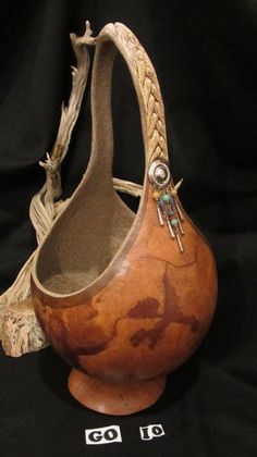 a wooden purse with braided handles on a black background