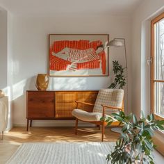 a living room with a painting on the wall and a chair in front of it