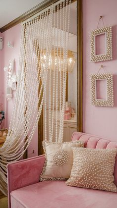 a pink couch sitting in front of a mirror