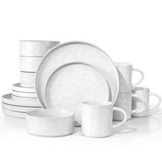 white dishes and cups are stacked on top of each other