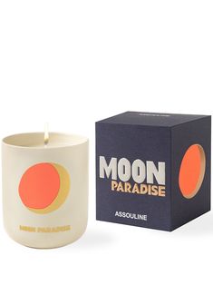 a candle that is next to a box on a white surface with the words moon paradise