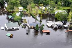 flood waters surround homes and trees in a flooded area